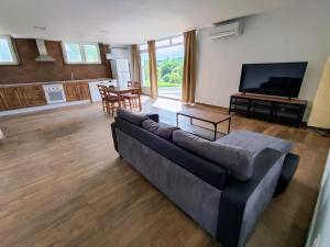 un soggiorno con un divano e una televisione di Preciosa Casa de Campo + Playa + Jardín + Mascotas a Naveces