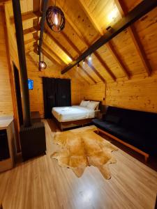 a room with a bed in a wooden cabin at Chalés De Cambará in Cambara do Sul