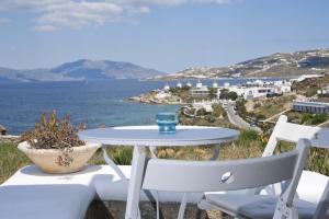 a table and chairs with a view of the ocean at Villa Margarita in Mýkonos City