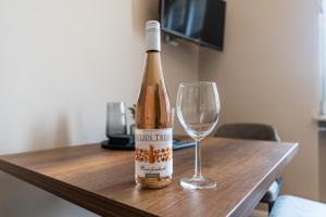 een fles wijn naast een wijnglas bij Moselresidenz Bellevue Alf Apartment Moselblick in Alf
