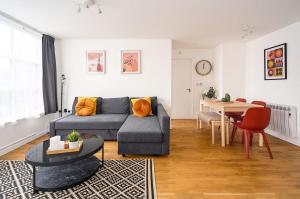 a living room with a couch and a table at Contemporary City Centre Apartment With Parking in Bath