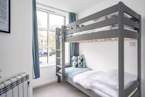 a bunk bed in a room with a window at Contemporary City Centre Apartment With Parking in Bath