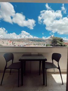 a table and two chairs in front of a window at Apartments Buljanovic in Pag