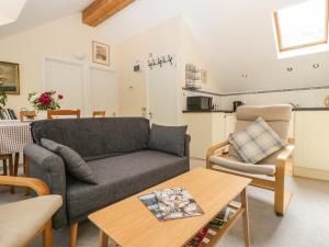 a living room with a couch and a table at The Loft At Nordrach Lodge in Bristol