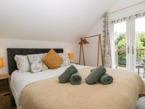 a bedroom with a bed with two stuffed animals on it at The Loft At Nordrach Lodge in Bristol