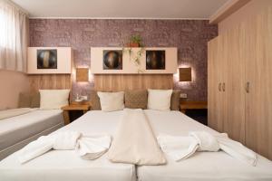 - une chambre avec 2 lits et des draps blancs dans l'établissement Hotel Orlando, à Sofia