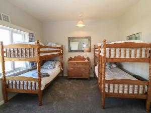Un dormitorio con dos literas y un espejo. en Wig Carna, en Holyhead