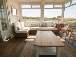 Una sala de estar con un sofá y una mesa de café. en Wig Carna, en Holyhead
