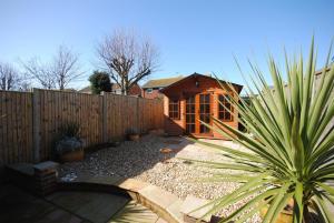 a backyard with a wooden fence and a house at Lifeboat View, Selsey in Selsey