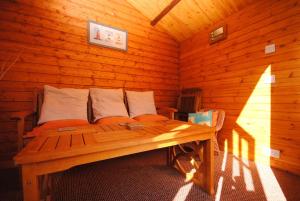 a wooden room with a bed in a log cabin at Lifeboat View, Selsey in Selsey