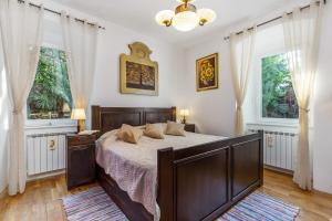 una camera con un grande letto e due finestre di Villa Carolina a Fiume (Rijeka)