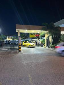 un coche amarillo estacionado frente a una gasolinera en Casa completa al frente del centro comercial alamedas en Montería