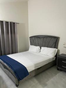 Un dormitorio con una cama grande con una manta azul. en TWO KING BEDS NEAR PUERTO SECO BEACH, en Discovery Bay