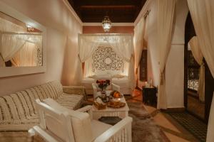 uma sala de estar com um sofá branco e uma mesa em Riad Dar Dialkoum em Marrakech