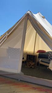 a tent with a bed and two chairs in it at Aspö Glamping in Drottningskär