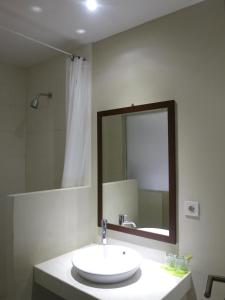 a bathroom with a sink and a mirror at Hart Hotel Arjuna in Mataram
