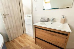 a bathroom with a sink and a mirror at Lake27apartman in Szántód