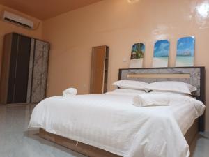 ein Schlafzimmer mit einem großen Bett mit weißer Bettwäsche und Kissen in der Unterkunft Tropical stay Thulusdhoo in Thulusdhoo