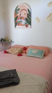 uma cama rosa com duas almofadas em cima em Le Petit Ecrin, 80 m de la mer em Le Pouliguen