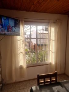 een raam in een kamer met een tv en een raam bij Departamento Tilcara in Neuquén