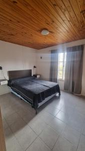 een slaapkamer met een groot bed en een houten plafond bij Departamento Tilcara in Neuquén