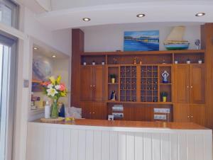 una cocina con armarios de madera y una barra con flores en Hotel Argibay, en O Grove