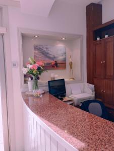 una cocina con una barra con un jarrón de flores en Hotel Argibay, en O Grove