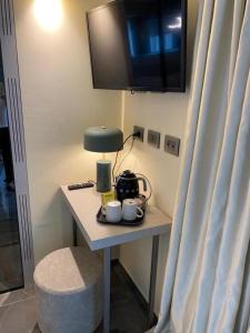 un tavolino con lampada e tazze sopra di Ale Suite Sea Side View - Hotel Arizona a Riccione