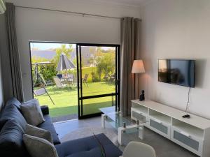 a living room with a blue couch and a tv at Casa com terraço e piscina Sagres in Sagres