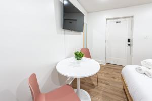 a white room with a table and chairs and a bed at Pastel Tropics Studio Apartment in Galveston
