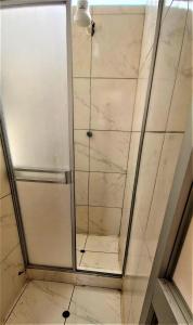 una doccia con una porta in vetro in un bagno di Carlos Guest House 2 Cusco a Cuzco