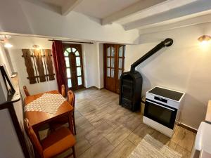 a living room with a stove and a table and a stove at Alföldi Vendégház - Dévaványa in Dévaványa