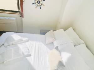 a white bed with white sheets and pillows at Il Mare Nel Pozzo Sperlonga Centro Storico Tutti i servizi sotto casa, a 100 mt dal mare Parcheggio multilivello adiacente, lasci la macchina e fai tutto a piedi! in Sperlonga