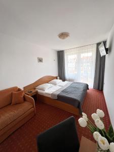 a bedroom with a bed and a couch at Willa Milano in Mielno