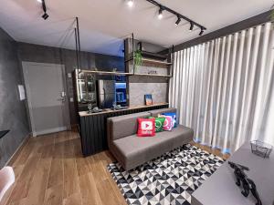 uma sala de estar com um sofá com almofadas num tapete em Condomínio Residencial Spazio Blu - São José do Rio Preto em São José do Rio Preto