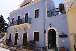 a white building with a balcony on a street at Faros Suites (Adults Only) in Fiskardo