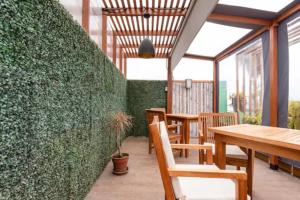 un patio con mesas y sillas y una pared verde en Amplio departamento en primer piso, en Lima
