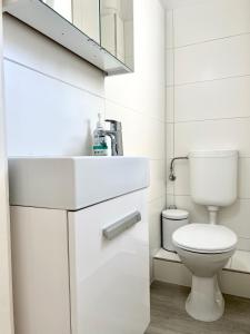 ein weißes Bad mit einem WC und einem Waschbecken in der Unterkunft Monteurzimmer in zentraler Lage in Emden