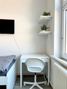 een wit bureau met een witte stoel in een kamer bij Monteurzimmer in zentraler Lage in Emden