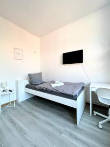 a bedroom with a bed and a tv on the wall at Monteurzimmer in zentraler Lage in Emden