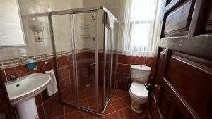 a bathroom with a toilet and a glass shower at Sultan Pension in Antalya