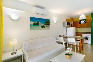 a living room with a white couch and a kitchen at Casa Puerto Rico in Mogán