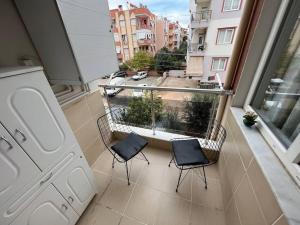 een balkon met 2 stoelen en uitzicht op de stad bij Очень уютная квартира 2+1 in Antalya
