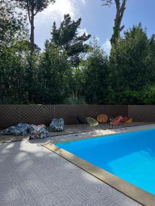 a swimming pool with chairs next to a fence at Résidence Chateau d'Acotz - Appartements avec piscine à 600m des plages à Saint-Jean-de-Luz in Saint-Jean-de-Luz