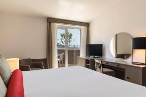 een hotelkamer met een bed, een bureau en een spiegel bij Paloma Perissia in Side