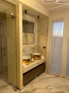 Un baño con dos lavabos y una ducha de cristal. en Ale Suite Sea Side View - Hotel Arizona, en Riccione