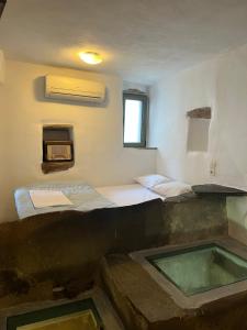 a room with two beds and a tub in it at Cellar Falatados in Mési