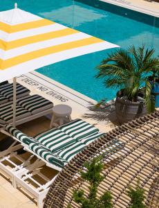 einen Liegestuhl und einen Sonnenschirm neben einem Pool in der Unterkunft CODA Williamsburg in Brooklyn