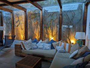 un salon avec un canapé devant un mur de verre dans l'établissement [porto ercole] comfort vista mare + parcheggio gratuito, à Cala Galera