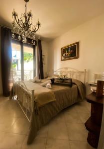 een slaapkamer met een bed met een kroonluchter en een raam bij Cala di Rio B&B in Termoli